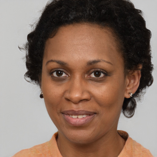 Joyful black adult female with short  brown hair and brown eyes