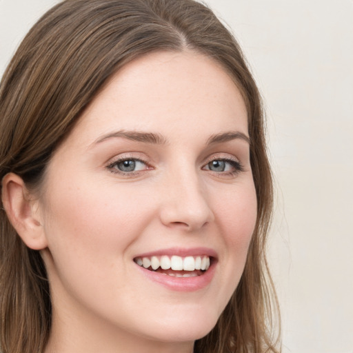 Joyful white young-adult female with long  brown hair and blue eyes