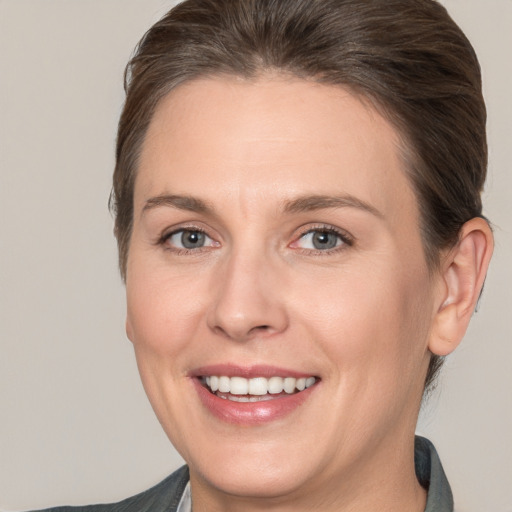 Joyful white adult female with medium  brown hair and brown eyes