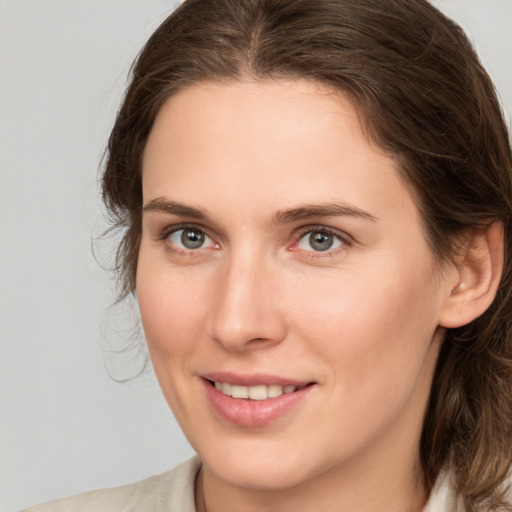 Joyful white young-adult female with medium  brown hair and grey eyes