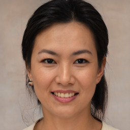 Joyful asian young-adult female with medium  brown hair and brown eyes