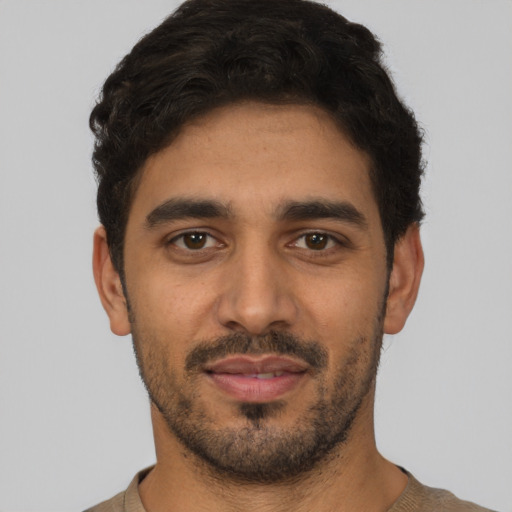 Joyful latino young-adult male with short  black hair and brown eyes