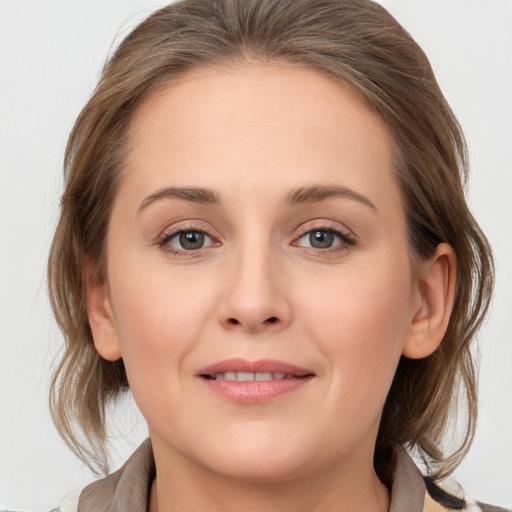 Joyful white young-adult female with medium  brown hair and grey eyes