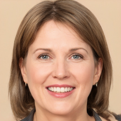 Joyful white adult female with medium  brown hair and grey eyes