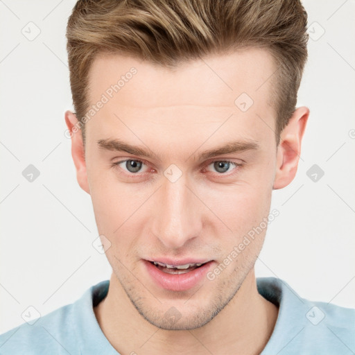 Joyful white young-adult male with short  brown hair and grey eyes