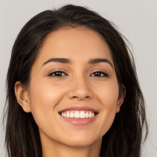 Joyful latino young-adult female with long  brown hair and brown eyes