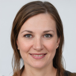 Joyful white young-adult female with medium  brown hair and grey eyes