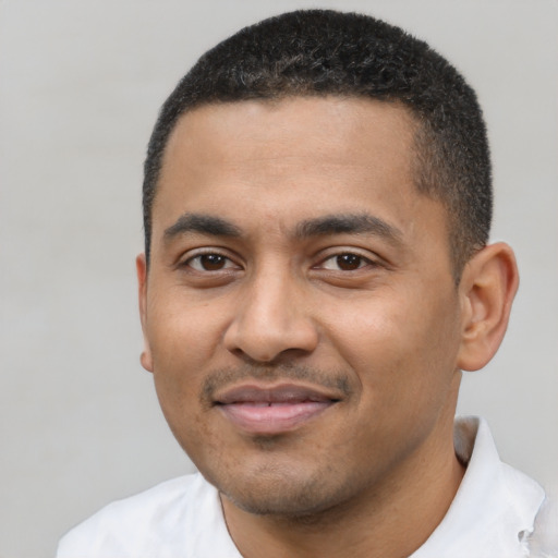 Joyful black young-adult male with short  black hair and brown eyes
