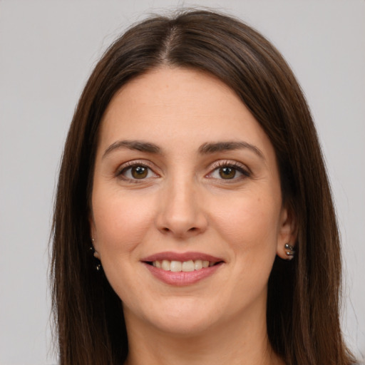 Joyful white young-adult female with long  brown hair and brown eyes