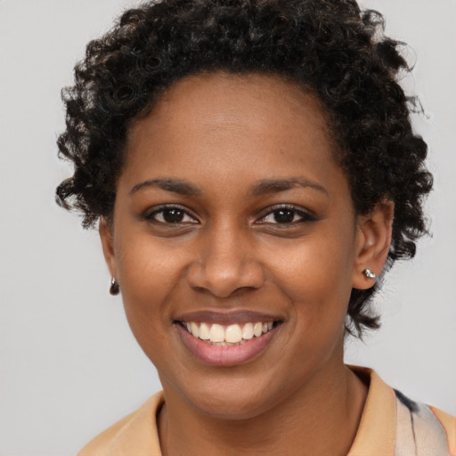 Joyful black young-adult female with short  brown hair and brown eyes