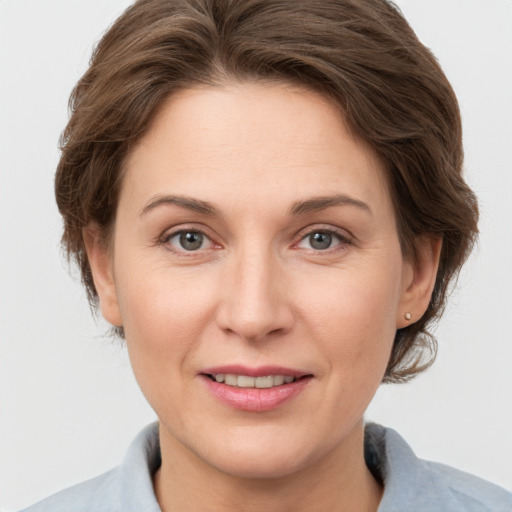 Joyful white adult female with medium  brown hair and grey eyes