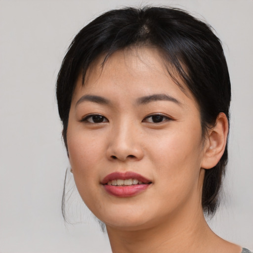 Joyful asian young-adult female with medium  brown hair and brown eyes