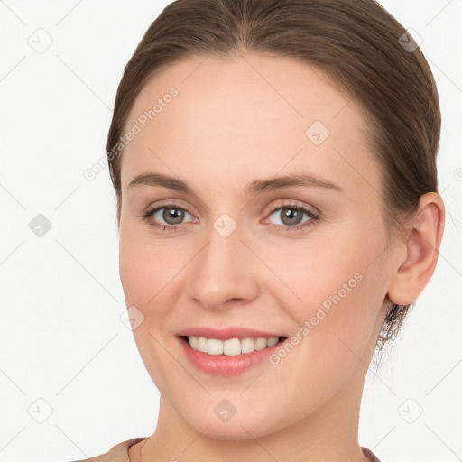 Joyful white young-adult female with long  brown hair and grey eyes