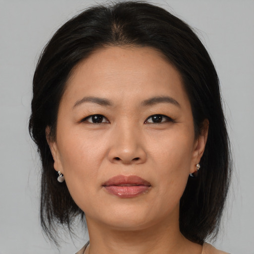 Joyful asian adult female with medium  brown hair and brown eyes