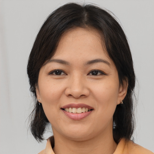 Joyful asian young-adult female with medium  brown hair and brown eyes