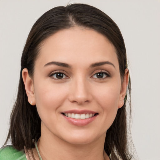 Joyful white young-adult female with long  brown hair and grey eyes