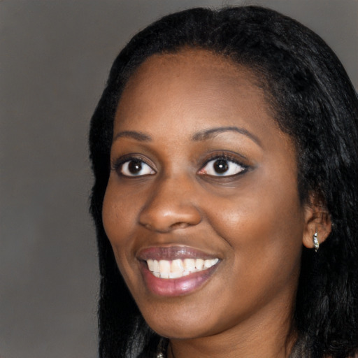 Joyful black young-adult female with long  black hair and brown eyes
