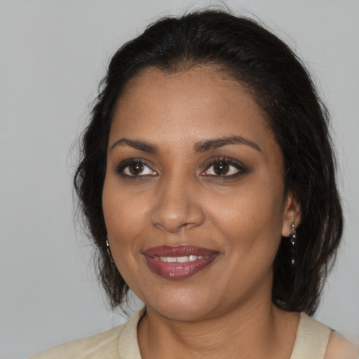 Joyful black adult female with medium  brown hair and brown eyes