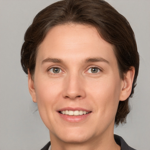 Joyful white young-adult female with medium  brown hair and grey eyes