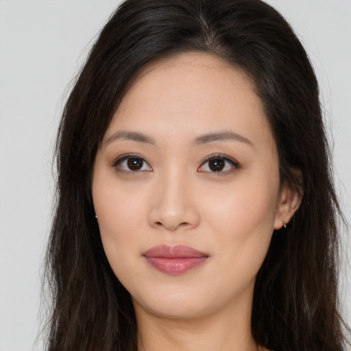 Joyful asian young-adult female with long  brown hair and brown eyes
