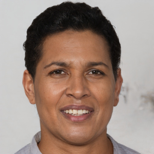 Joyful latino adult female with short  black hair and brown eyes
