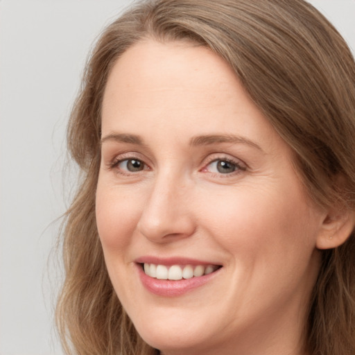 Joyful white adult female with long  brown hair and brown eyes