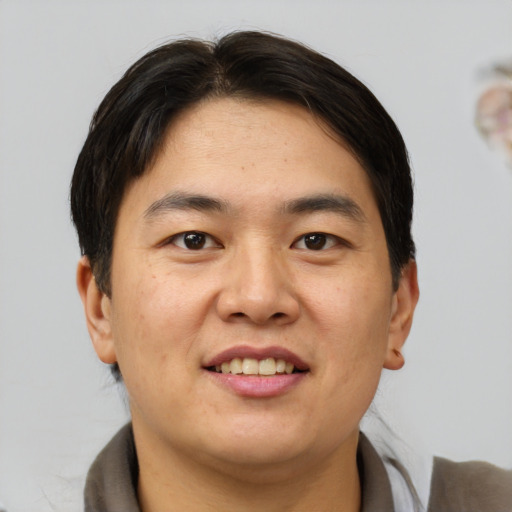Joyful asian young-adult male with short  brown hair and brown eyes