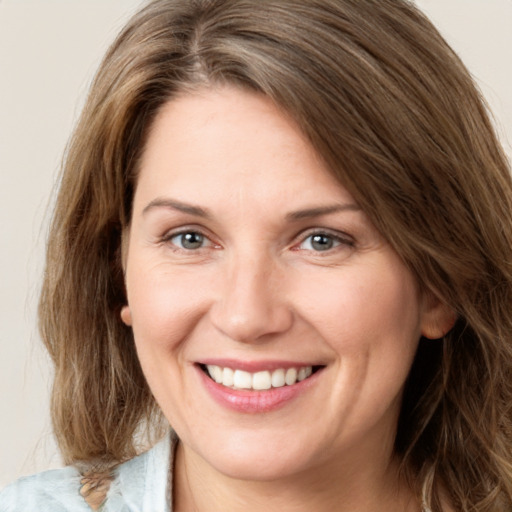 Joyful white young-adult female with medium  brown hair and green eyes