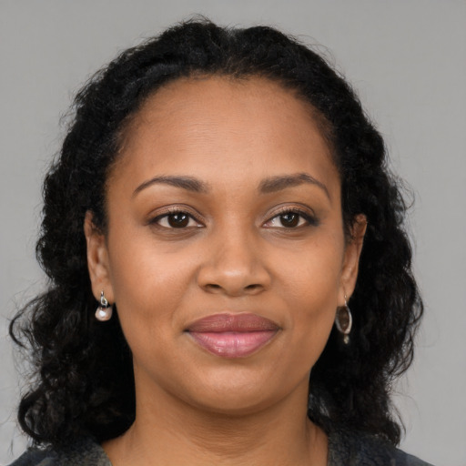 Joyful black young-adult female with long  brown hair and brown eyes