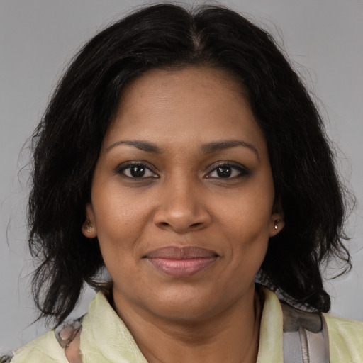 Joyful black adult female with medium  brown hair and brown eyes