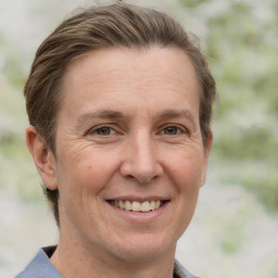 Joyful white adult female with medium  brown hair and grey eyes