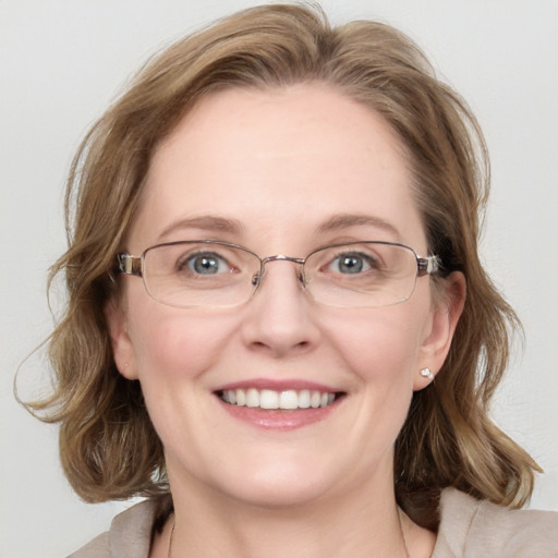 Joyful white adult female with medium  brown hair and blue eyes