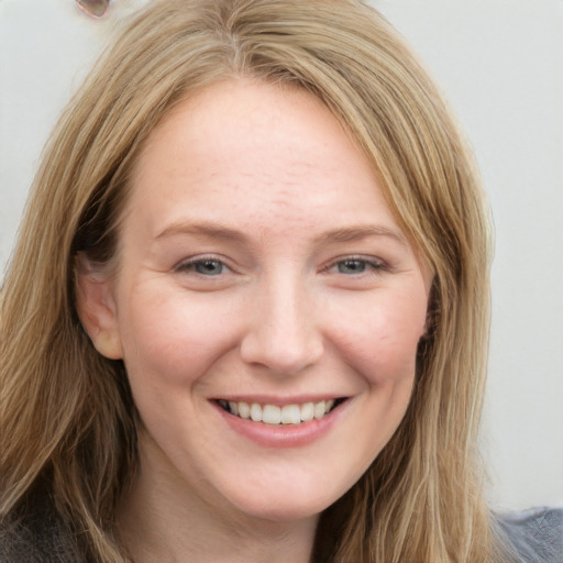 Joyful white young-adult female with long  brown hair and blue eyes