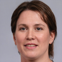 Joyful white young-adult female with medium  brown hair and grey eyes