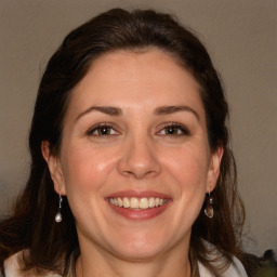 Joyful white adult female with long  brown hair and brown eyes