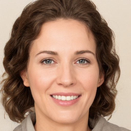 Joyful white young-adult female with medium  brown hair and green eyes