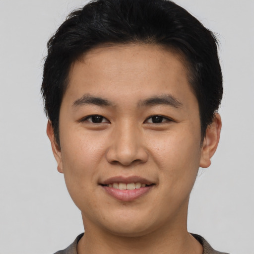 Joyful asian young-adult male with short  brown hair and brown eyes