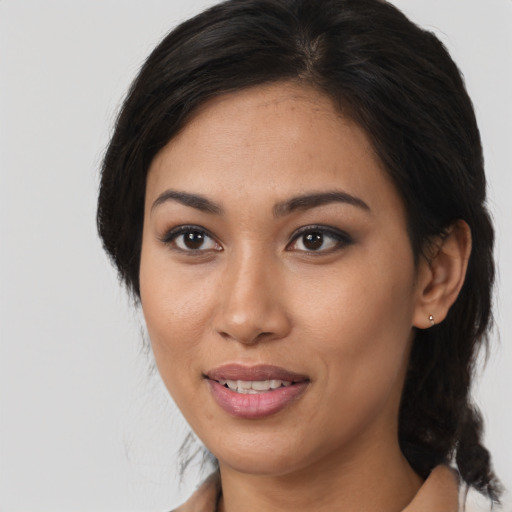 Joyful latino young-adult female with medium  brown hair and brown eyes