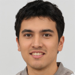 Joyful latino young-adult male with short  brown hair and brown eyes