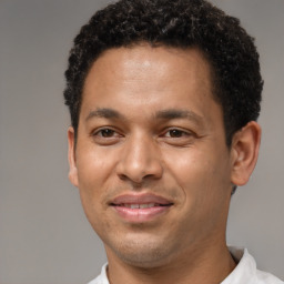 Joyful latino young-adult male with short  brown hair and brown eyes