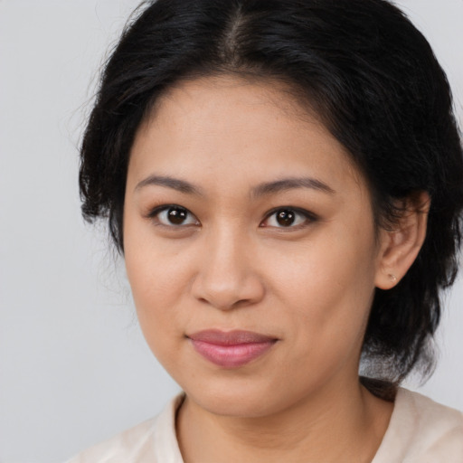 Joyful latino young-adult female with medium  brown hair and brown eyes