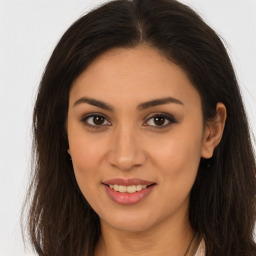 Joyful latino young-adult female with long  brown hair and brown eyes