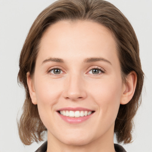 Joyful white young-adult female with medium  brown hair and green eyes