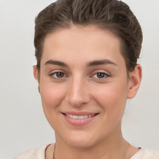 Joyful white young-adult female with short  brown hair and grey eyes