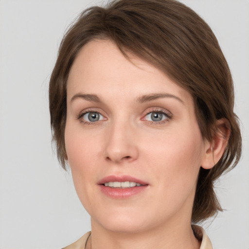 Joyful white young-adult female with medium  brown hair and grey eyes