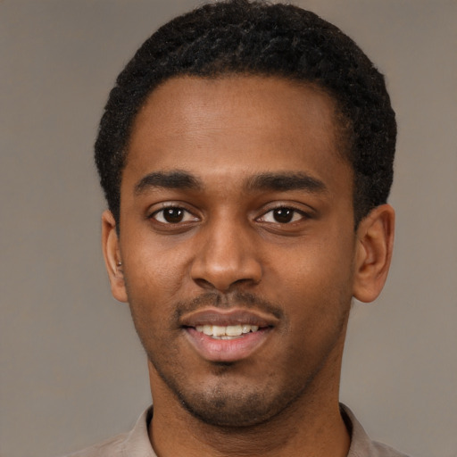 Joyful black young-adult male with short  black hair and brown eyes