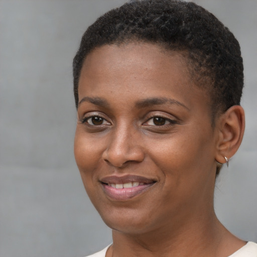 Joyful black young-adult female with short  brown hair and brown eyes