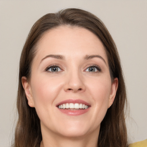 Joyful white young-adult female with long  brown hair and grey eyes