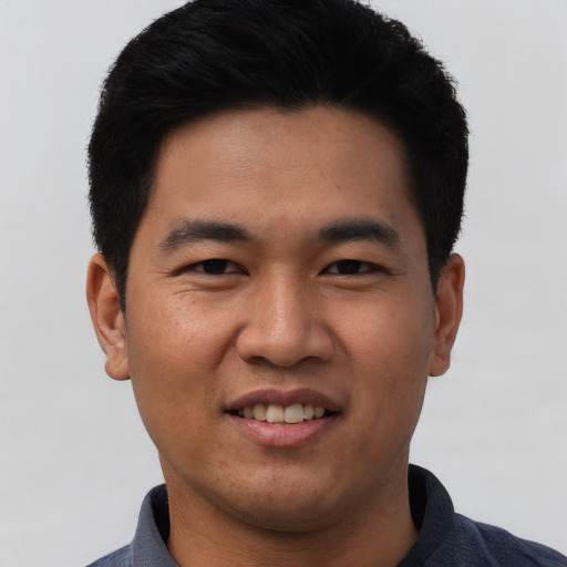 Joyful asian young-adult male with short  black hair and brown eyes
