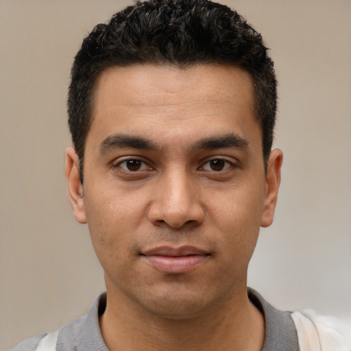 Joyful latino young-adult male with short  black hair and brown eyes